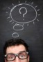 Photo of man in front of a blackboard with a thought bubble drawn on it
