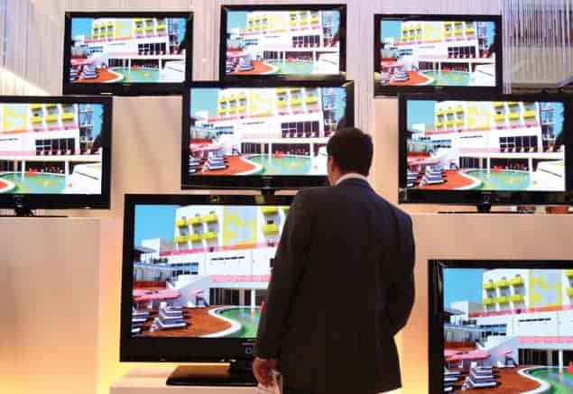 Picture of man looking at huge TV screens