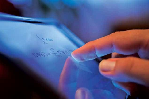 A person's forefinger touches the screen of a tablet computer, which is displaying the Schrodinger equation as it appears when generated by the LaTeX typesetting tool