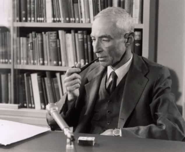 Photo of Robert Oppenheimer smoking a pipe in the library at CERN