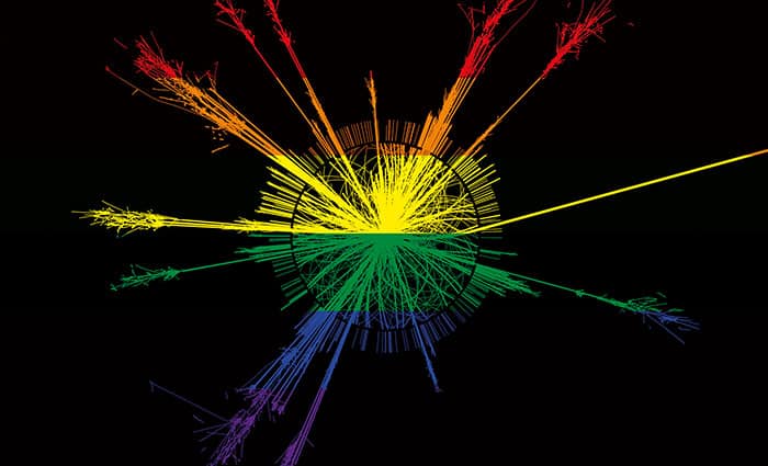 Image of particle tracks emanating radially outwards from a collision point, coloured with the six-coloured Pride flag so that the particle tracks are rainbow-coloured on a black background