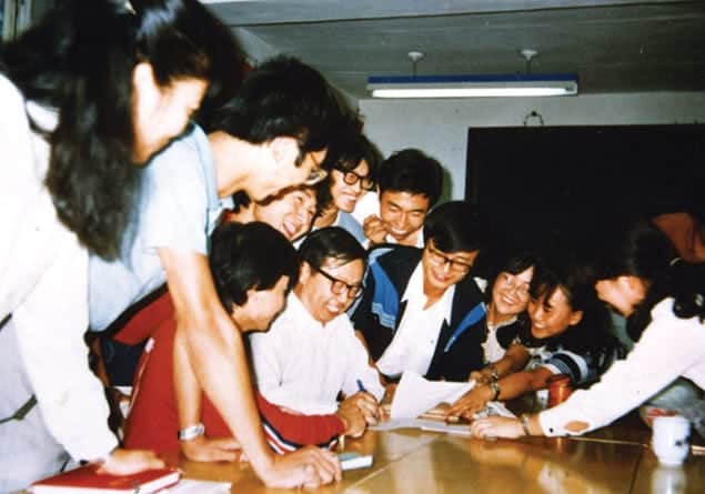 Photo of a smiling Fang Lizhi surrounded by happy students