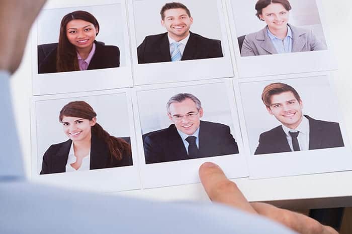 Photograph showing someone choosing a candidate from a selection of photographs