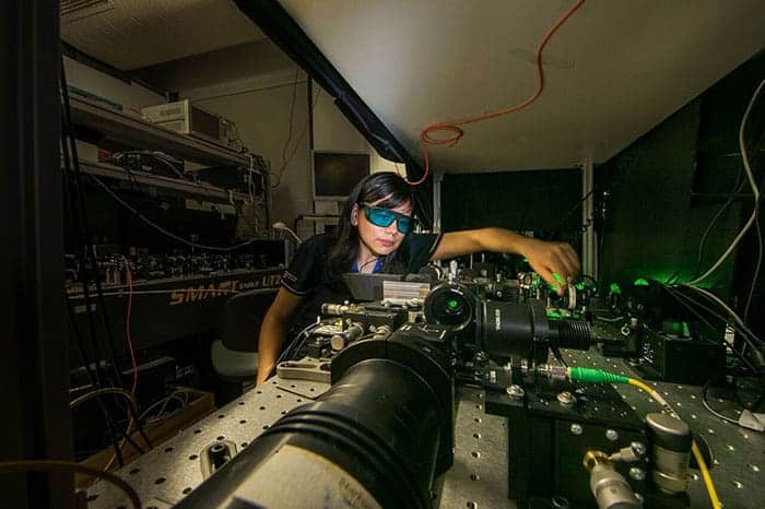 Photograph of a researcher in an optical lab at ANU