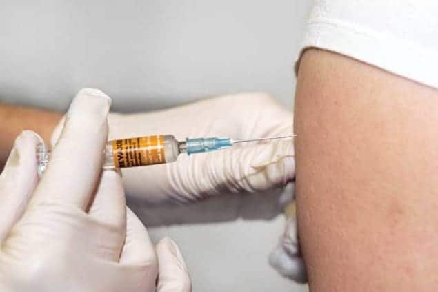 The polio vaccine being administered to an adult patient