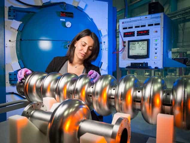Photograph of Anna Grassellino of Fermilab with superconducting RF cavity Photograph of Anna Grassellino of Fermilab with superconducting RF cavity