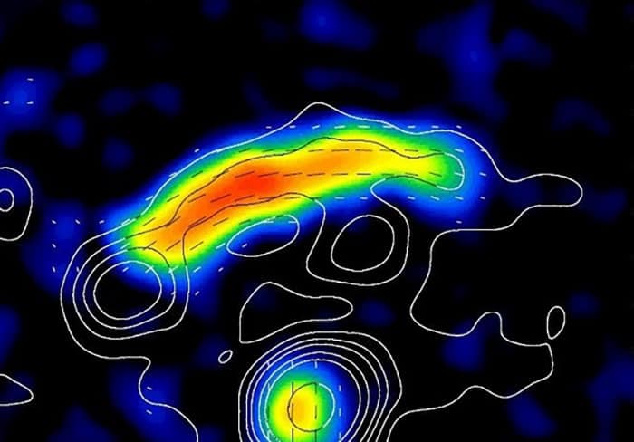 Relic of galaxy cluster CIZA J2242+53 - contour lines show intensity of radio emissions (3 cm wavelength), colours show distribution of linearly polarized radio intensity, dashed lines show orientation of magnetic field