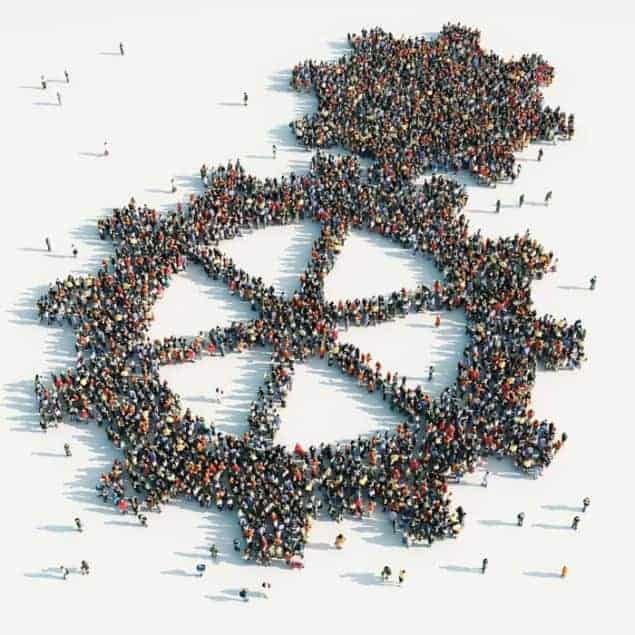 Computer-graphic aerial view of hundreds of people standing in a way that looks like two adjoined cogs Computer-graphic aerial view of hundreds of people standing in a way that looks like two adjoined cogs