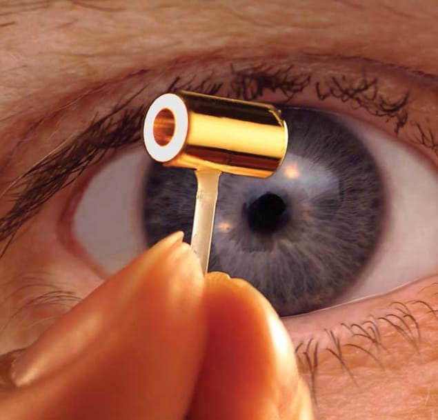 Photo showing a hohlraum – a tiny gold-coated cylinder with a thin tube extending from the curved side – being grasped in a person