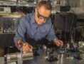 Photograph of Dave Howe aligning a laser beam to pass through a tiny glass cell of rubidium atoms