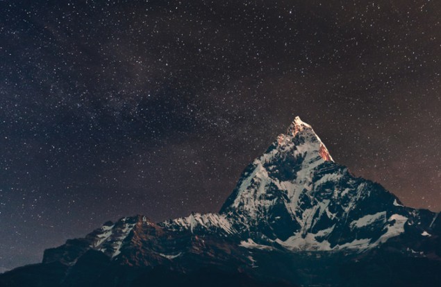 Photograph of a starry sky above a mountain