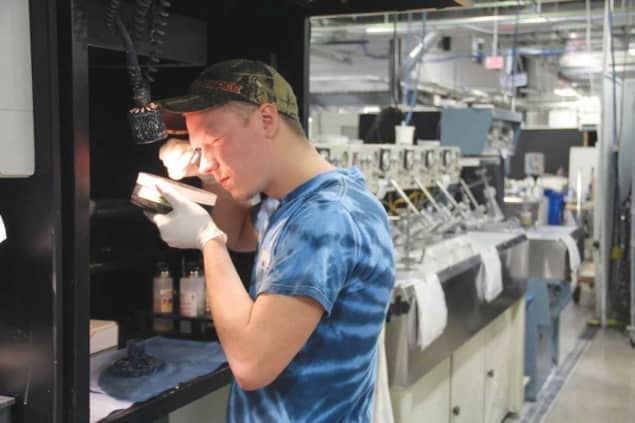 An Optimax employee examines a prototype optic