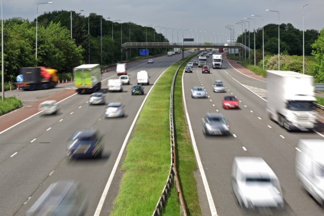 Photo of heavy traffic moving at speed on the M6 motorway in England. (Courtesy: iStock/BrianAJackson)