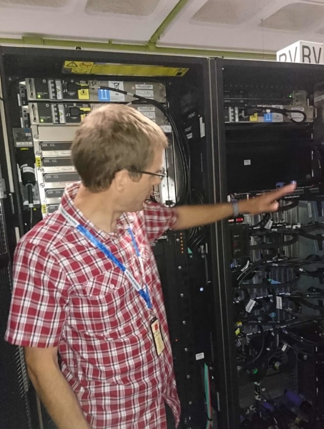 A man pointing at a large mainframe computer