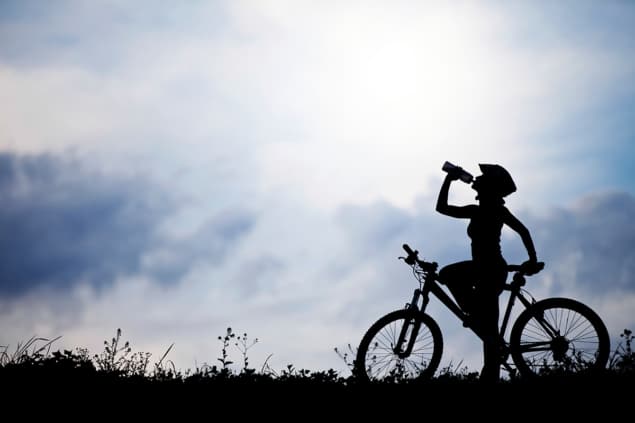 Photo of cyclist in front of sky