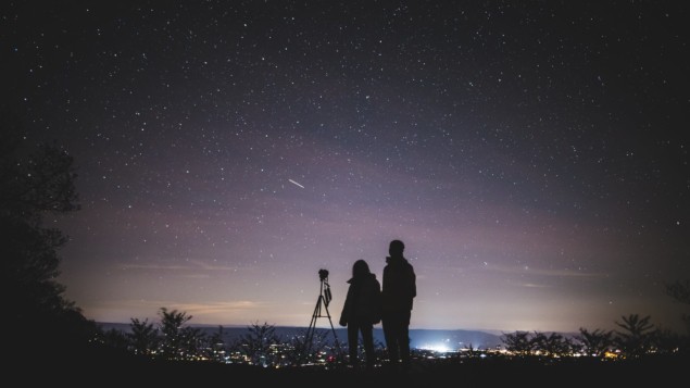 Photo of people looking at the night sky
