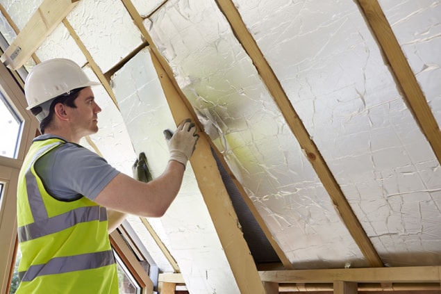 Photo of worker installing insulation Photo of worker installing insulation