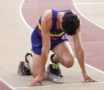 A runner crouches in the starting blocks on a track