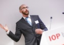 Photo of Rob Campling standing behind a podium with an IOP logo and gesturing