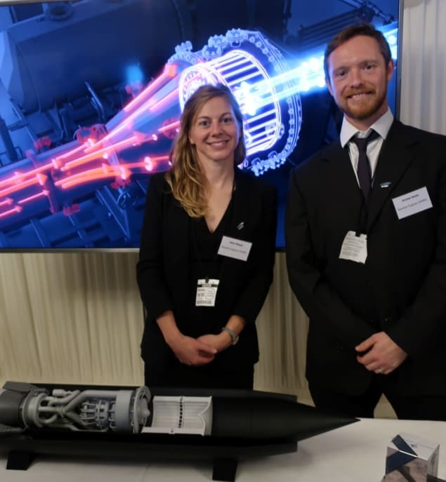 Helen Webber and Andrew Davies standing in front of a screen displaying an artist's impression of the SABRE engine