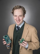 A photo of Anatole von Lilienfeld holding circuit boards