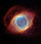 An image of the Helix Nebula, which looks like a blue eye surrounded by a red eye socket and lid