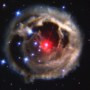 A bright red star surrounded by a wispy envelope of glowing gas