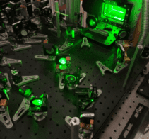 Optical elements such as mirrors and lenses directing green light around an optical bench