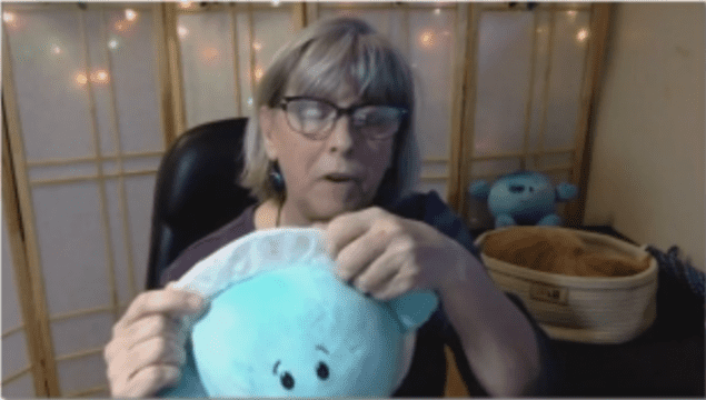 Heidi Hammel holding a cute stuffed toy version of Uranus with eyes drawn on and a ring stitched around its edge