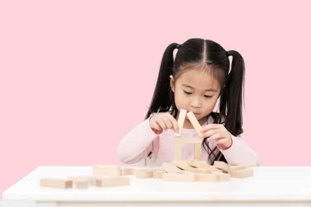 child playing with wooden blocks