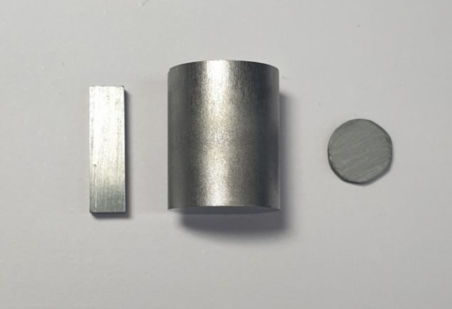 Photo of tin selenide pellets. The material is dull grey in colour and somewhat reflective