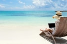 Woman using a laptop at the beach