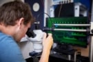 Photo of a man looking through a microscope