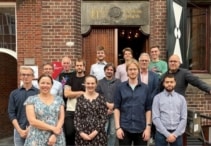 Photo of members of the NL-eEDM team standing on the stairs outside their laboratory