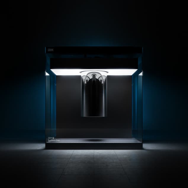 A photograph of IBM's Quantum System One suspended from a platform and bathed in dim light