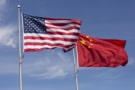 American Chinese windy day flags fly together on flagpole