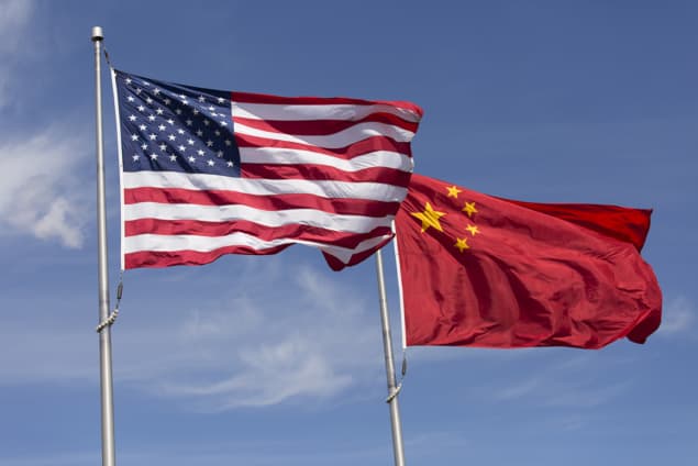 American Chinese windy day flags fly together on flagpole