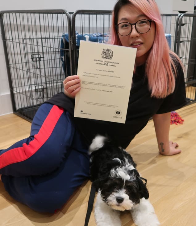 Lia with her puppy and papers from setting up her company