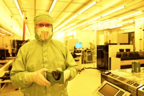 Smart Photonics employee Luc Augustin in a cleansuit holds a wafer containing photonic chips