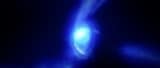 Artist's impression of the galaxy MACS1149-JD1, consisting of a whorl of stars and a diffuse jet of pale blue light, suggesting motion