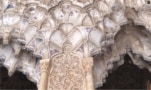 Foto di muqarnas - minuscole cavità arcuate nidificate insieme come un nido d'ape - all'Alhambra, che mostra lo scolorimento viola sulla superficie.