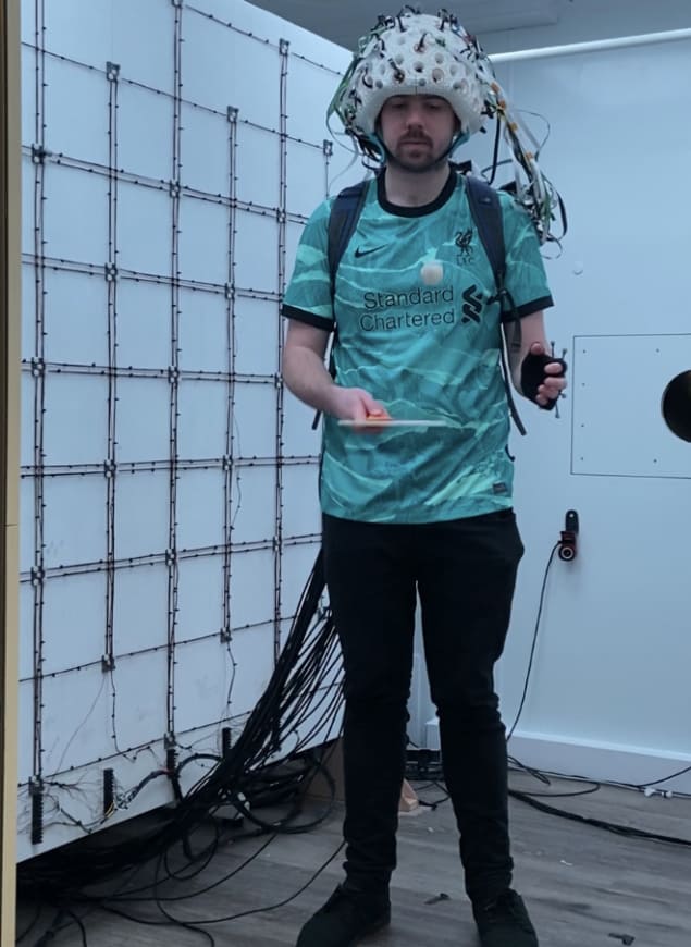 Researcher Niall Holmes wears the brain imaging helmet