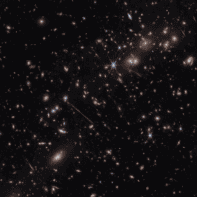 Image of many galaxies on a dark background. Two of the most prominent features in the image include the Thin One, located just below and left of the image center, and the Fishhook, a red swoosh at upper right.