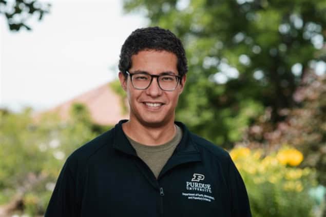 Photo of Dan Chavas in front of trees and flowers