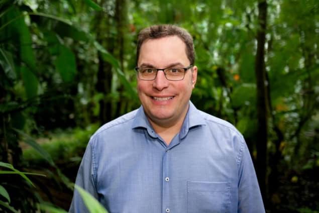 Photo of team leader Johannes Quaas, in a blue shirt, in a dense forest