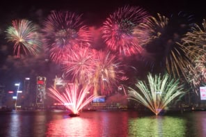 Photo of fireworks exploding over a body of water