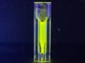 A small vial containing fluorescent yellow supraparticles