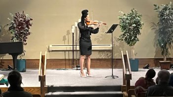 Michelle Lollie playing violin on stage for an audience