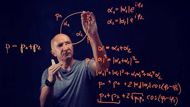 Artur Ekert Photo of Artur Ekert solving maths equations on a glass screen