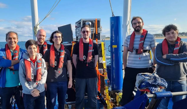 Group of people and equipment on the deck of a boat Group of people and equipment on the deck of a boat